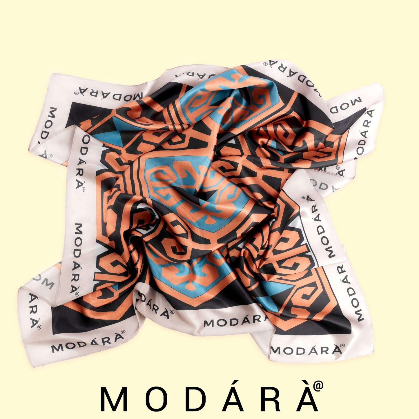 Colorful patterned scarf with 'MODÔRA' branding on a light yellow background